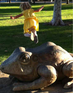 Leaping off a stone frog at the park